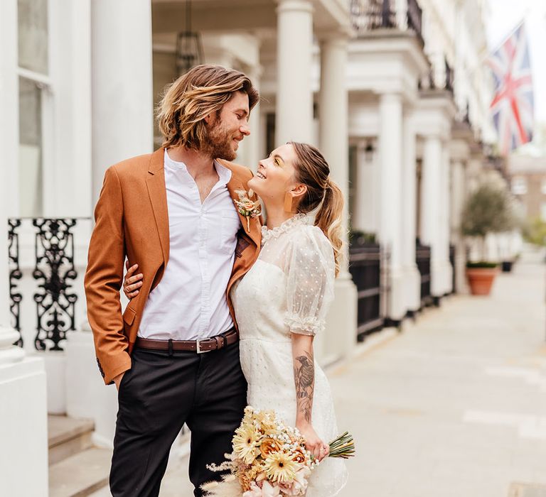 Styling bride and groom portrait at Chelsea micro wedding with bride in orange platforms and floral patterned socks 