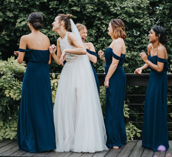 Bridesmaids wearing floor length navy bridesmaid dresses with off shoulder sleeve and sweetheart neckline | Jarlo Dresses | Fern Edwards Photography