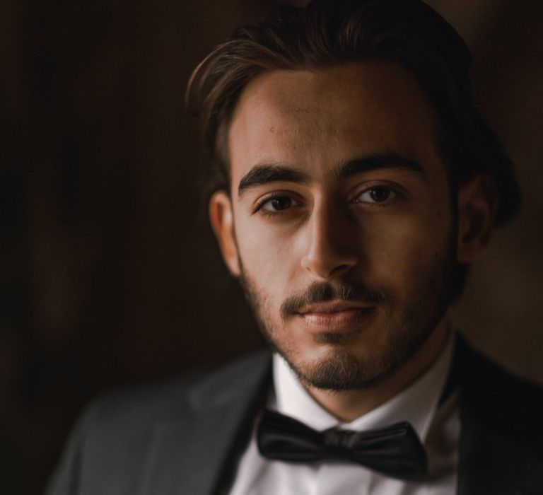 Groom wears black tie attire on his wedding day