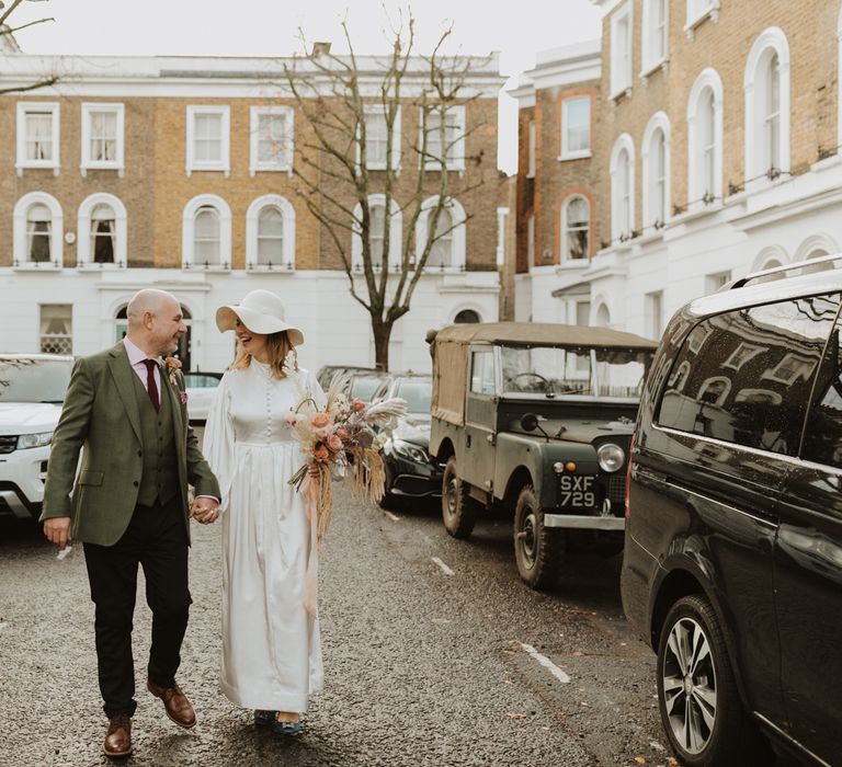 Bride & groom walk through Chelsea whilst holding hands