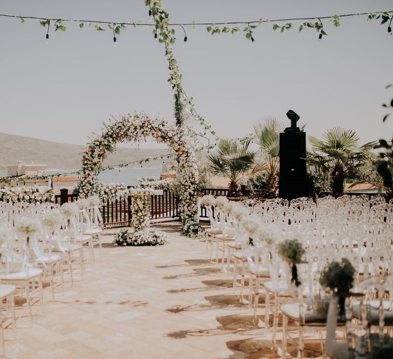 All white colour scheme and white flower arch for outdoor Turkish wedding ceremony