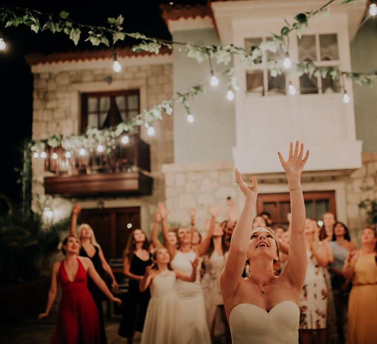 The bride throwing her bouquet into the air behind her