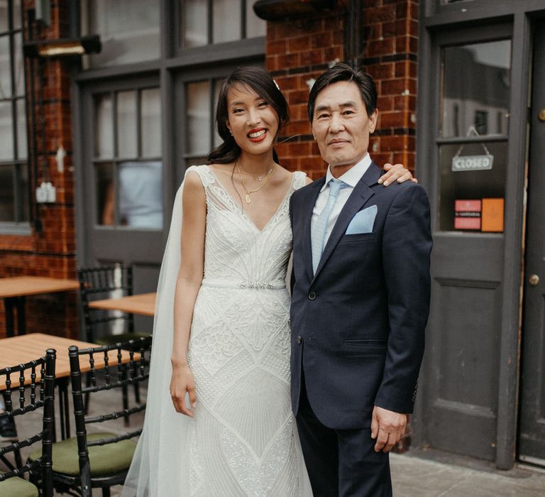 The bride standing with her father outside the pub wedding reception