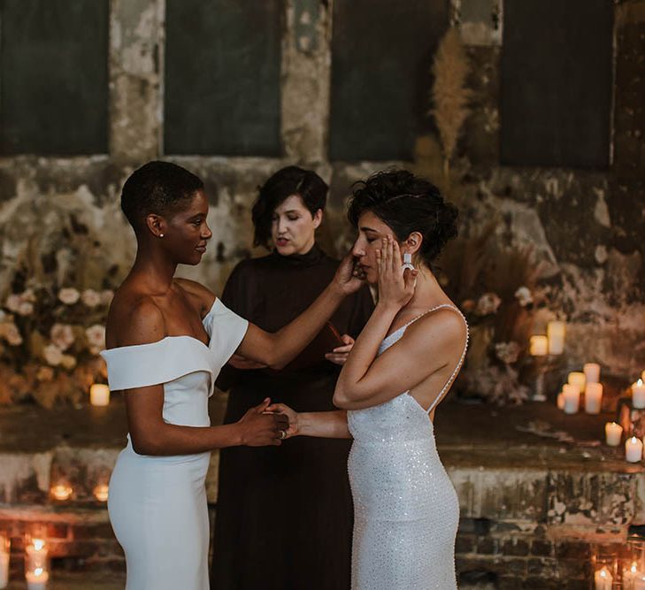 Emotional same-sex wedding ceremony with brides in a strapless and sequin wedding dress at The Asylum wedding venue 