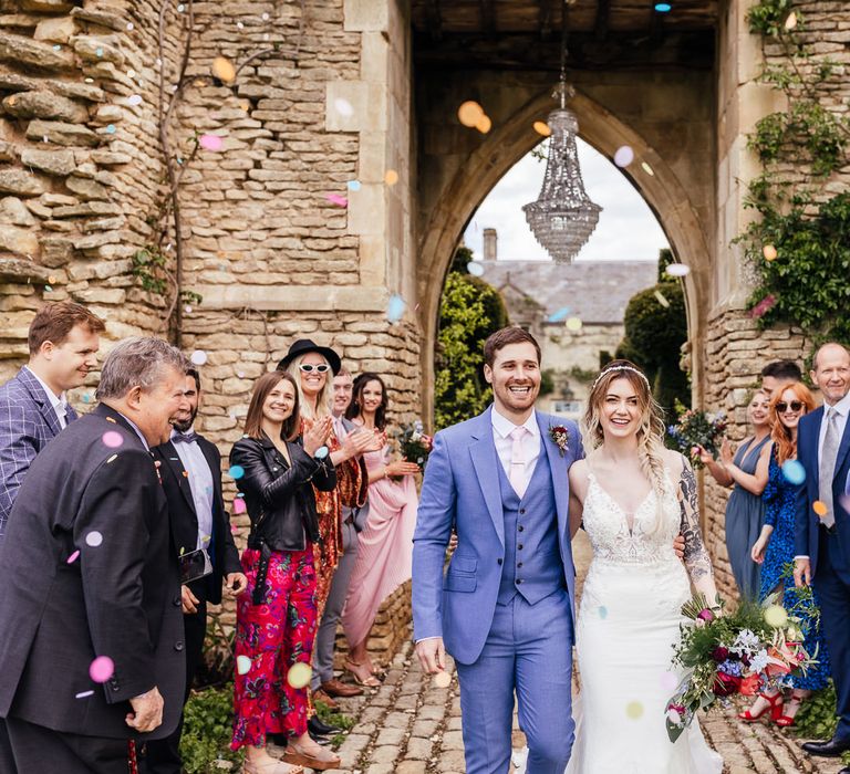 Bride & groom walk through colourful confetti 