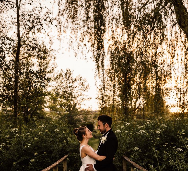 Bride & groom embrace and look lovingly at one another on their wedding day