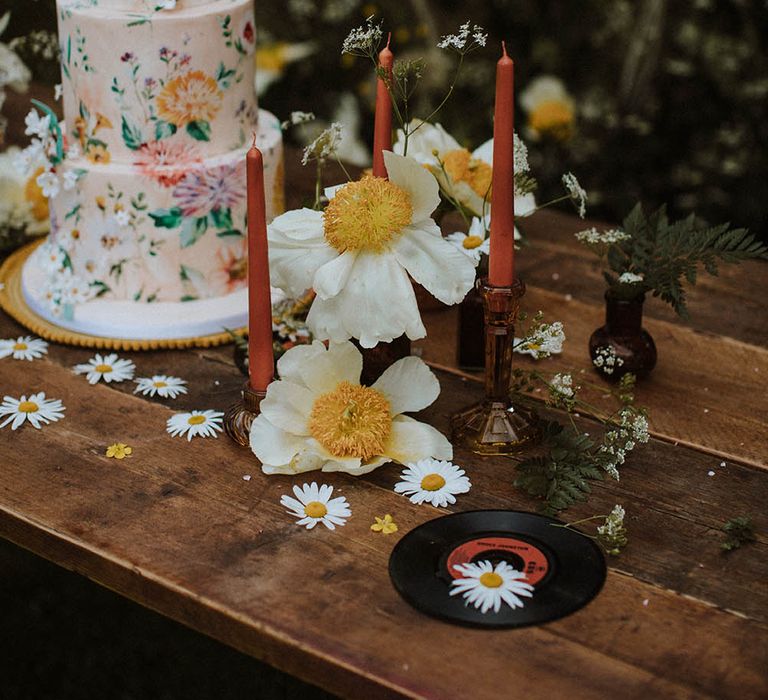 vintage record, candles and wildflower decor on the cake table for sixties wedding inspiration