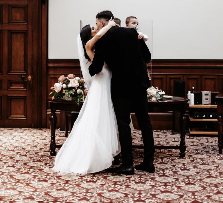 Bride & groom kiss during wedding ceremony at St George's Hall Liverpool