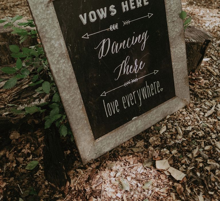 Personalised chalkboard framed sign leaning against tree