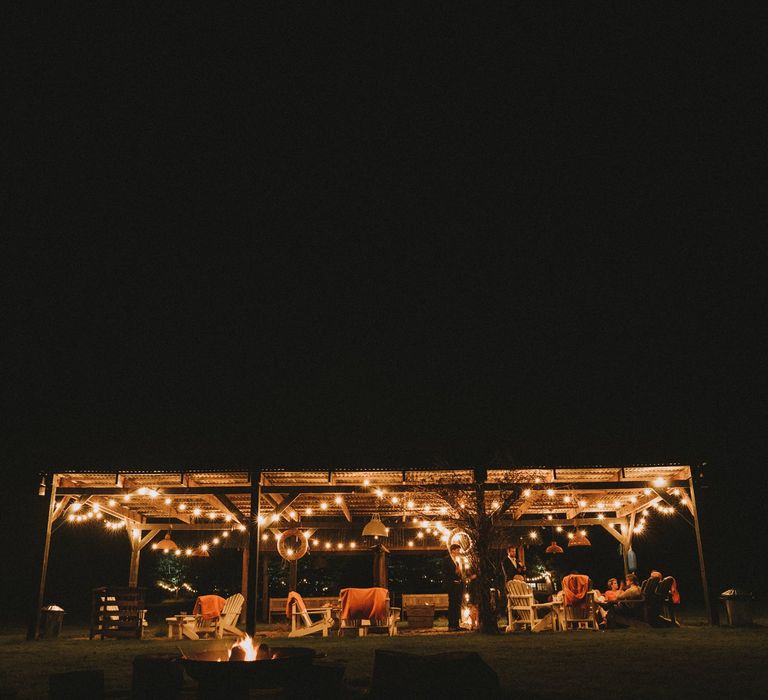 Outdoor seating area at Osea Island wedding venue with festoon light decor 