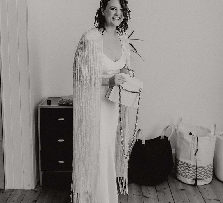 Black & white image of bride wearing wedding cape on her wedding day