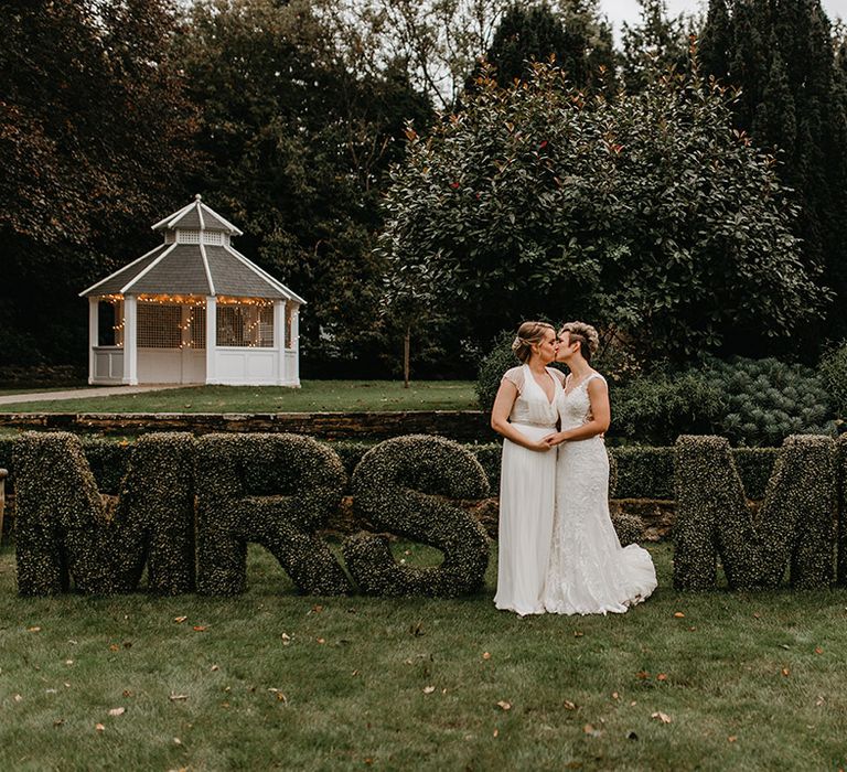 Brides stand outdoors on their wedding day