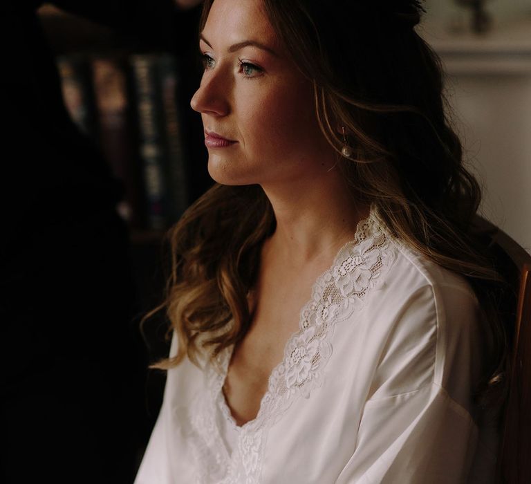 Bride in white lace getting ready robe