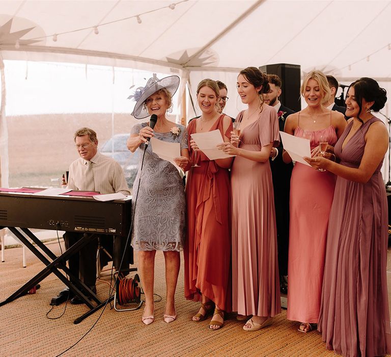 Bridesmaids in mismatched dresses make speech at wedding