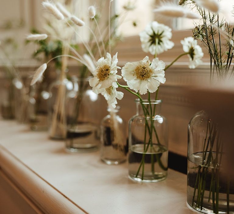 White flowers in glass vases for wedding reception table settings