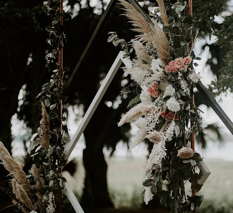 Square altar decoration with fresh pink flowers, foliage and dried grass