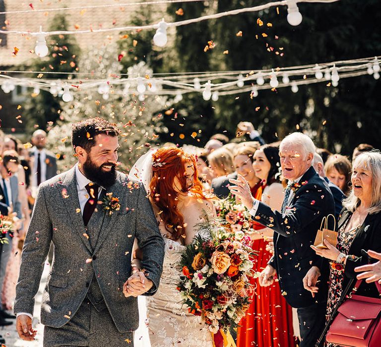 Bride and groom smile brightly as they have their confetti exit 