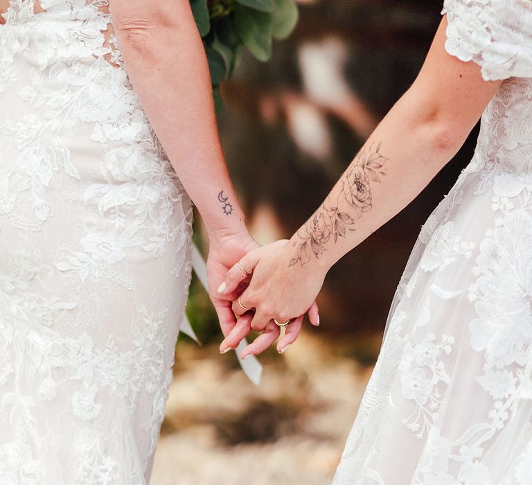 Brides holding hands together as they marry at The Dreys wedding venue 