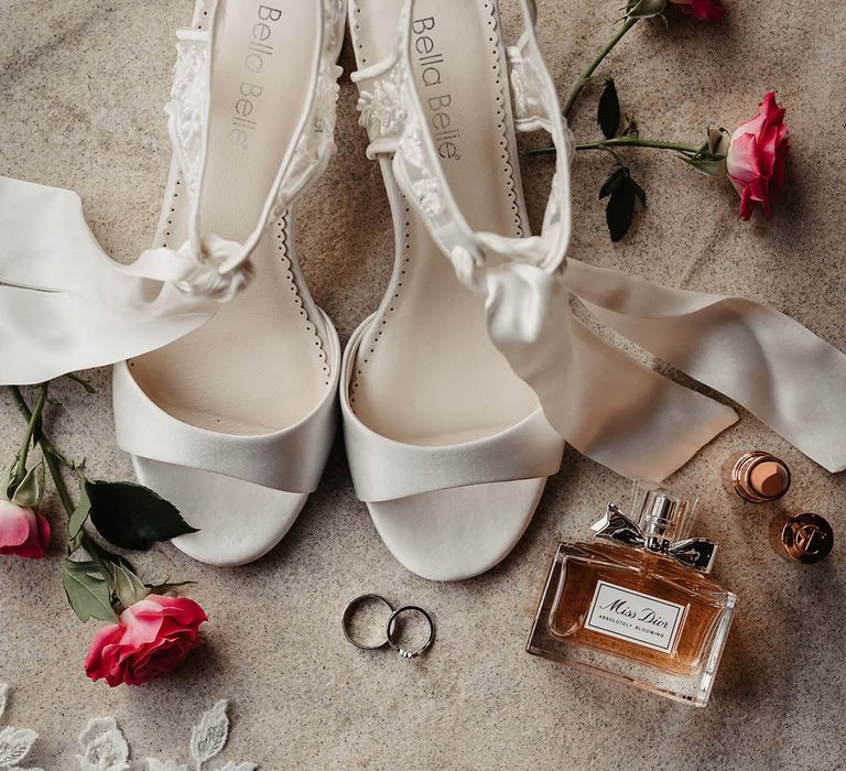 Bridal accessories with white ribbon Bella Belle heels with Dior perfume and Charlotte Tilbury lipstick 