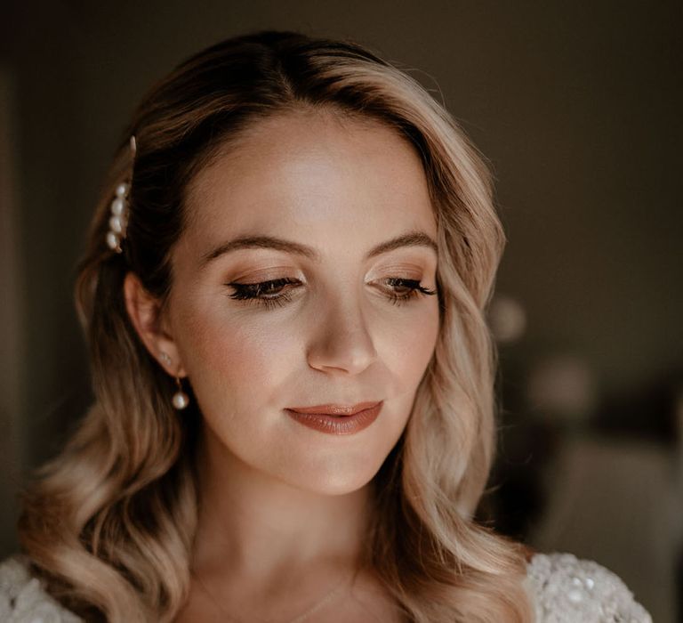 Bride with soft glowy makeup with pearl hair clips with the bride in a long sleeve Badgley Mischka wedding dress 