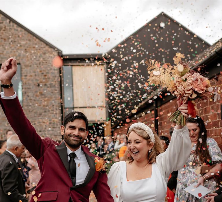 Fun and colourful confetti exit for the bride and groom after their multicultural humanist wedding ceremony 