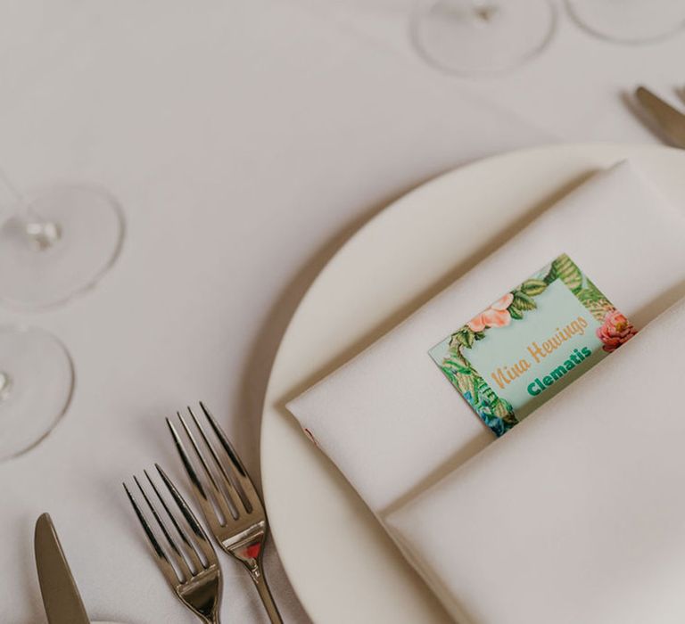 White fabric napkin complete with floral illustrated stationery tucked within 