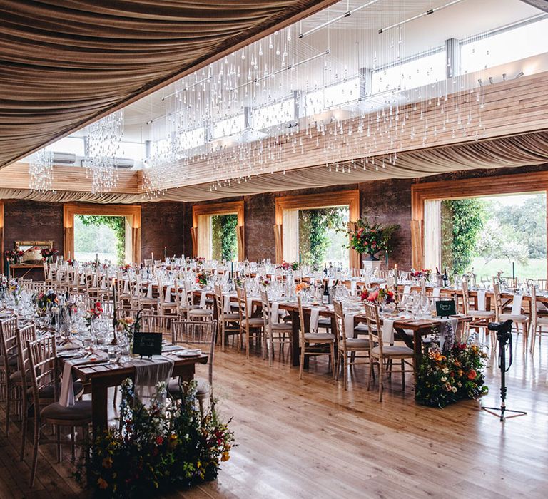 Elmore Court wedding venue with long banquet tables covered with white table runners and subtle pops of green from the wedding stationery and favours 