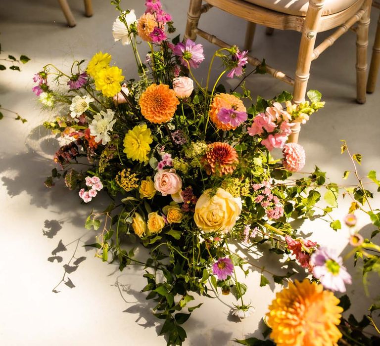 Summer wedding flower aisle arrangement decor with pink, yellow, and orange dahlias, roses and more 