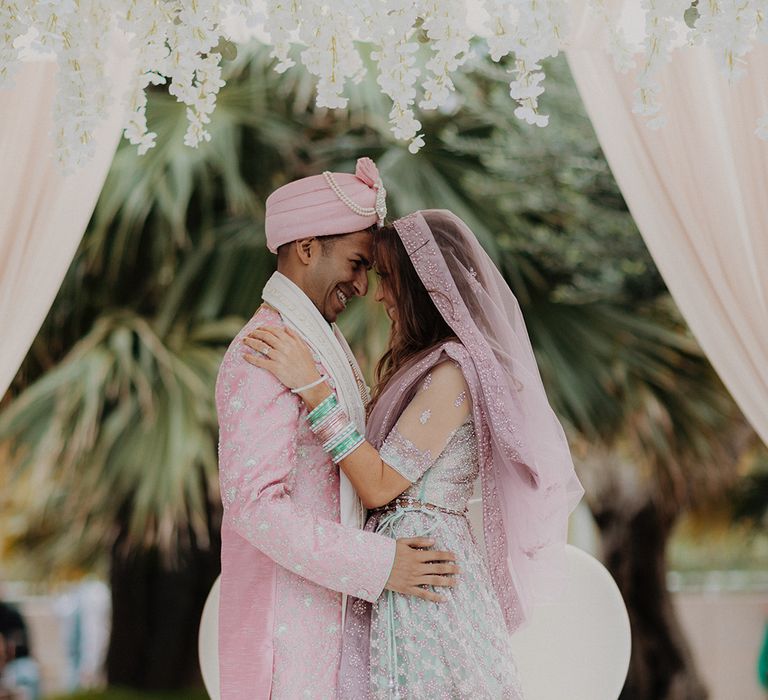 Bride and groom embracing in the wedding mandap at traditional Indian wedding in Barcelona 