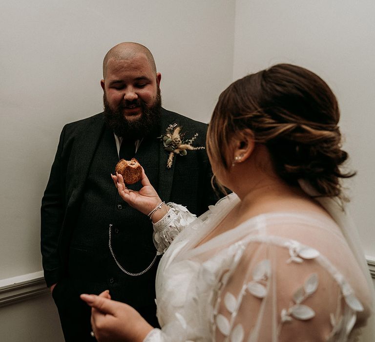 The bride feeds the groom a pork pie as they cut their cheese tower 