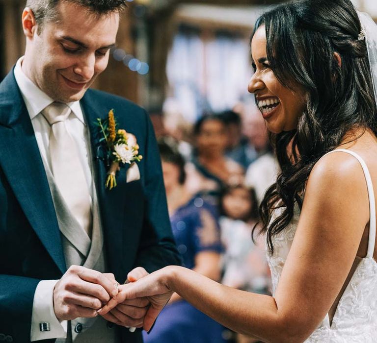 Bride and groom doing ring exchange at the alter of South Farm wedding venue in Cambridgeshire