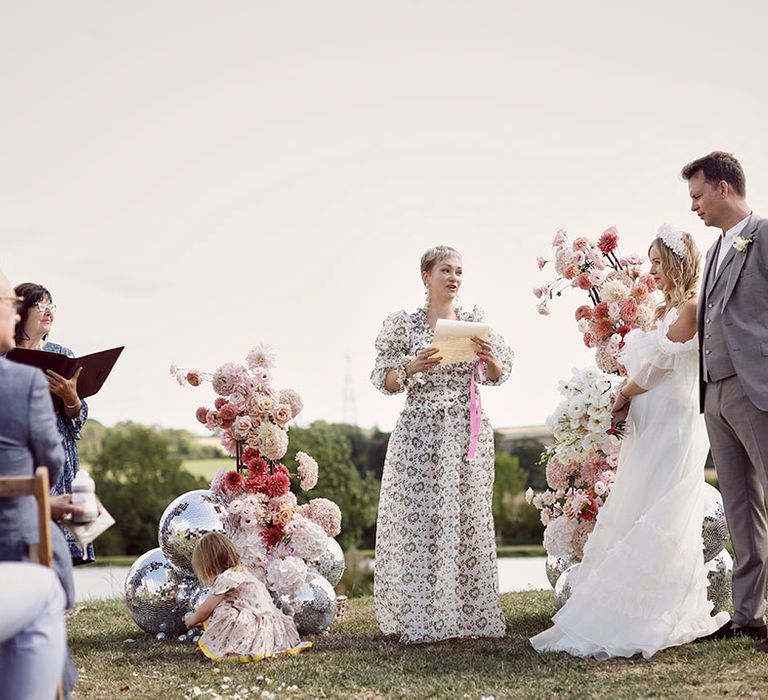 Bridesmaid in puff sleeve dress performing a wedding reading poem at the humanist outdoor wedding at Anran wedding venue 