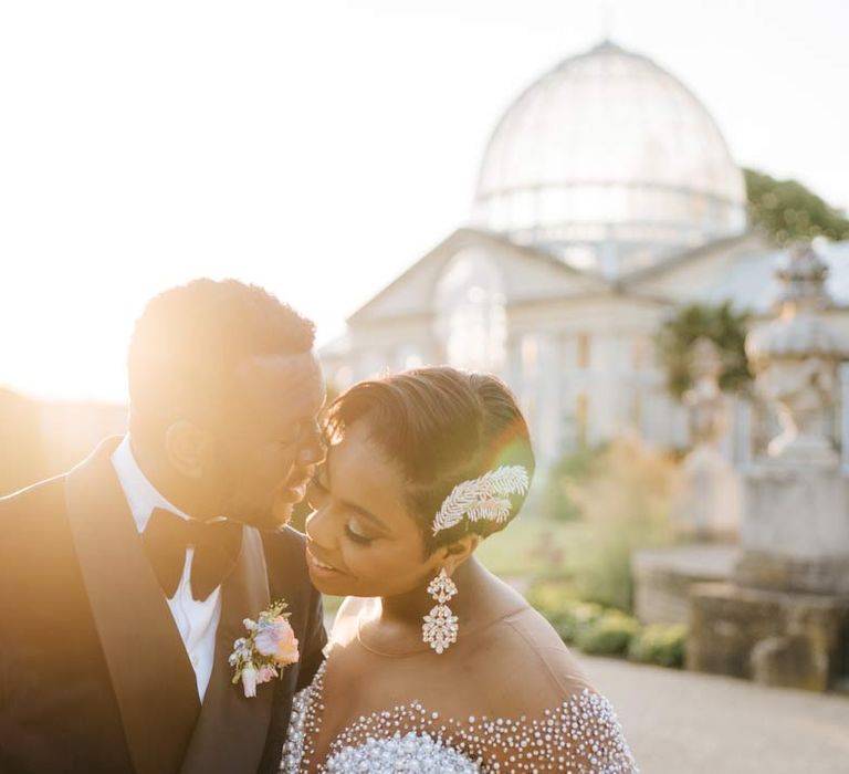 Bride and groom during golden hour standing outside of Syon Park wedding venue for their vow renewal ceremony 