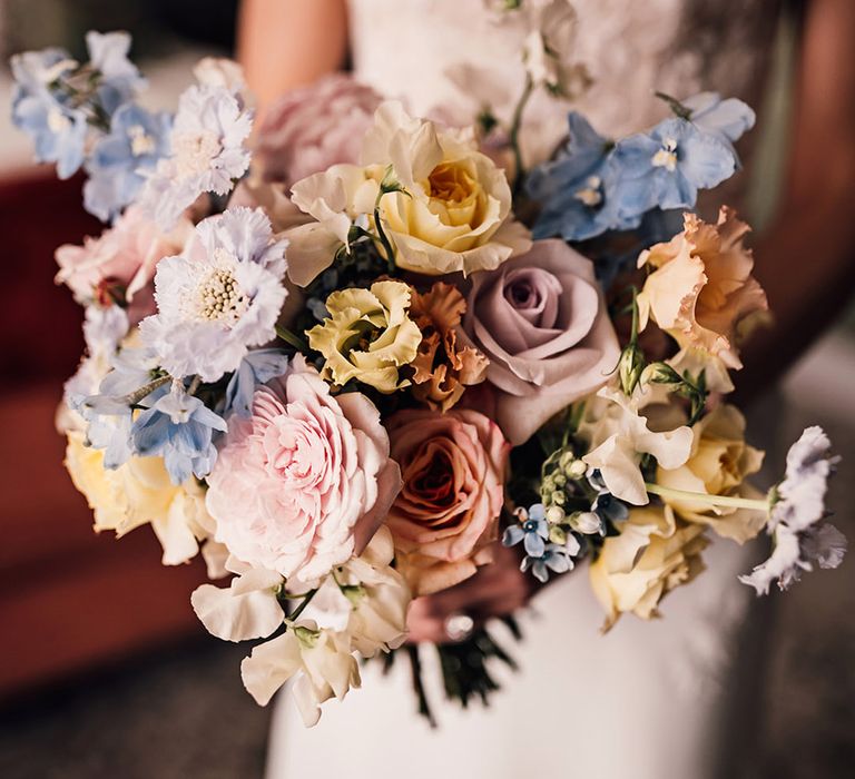 Pastel yellow, pink, and blue wedding bouquet with roses 