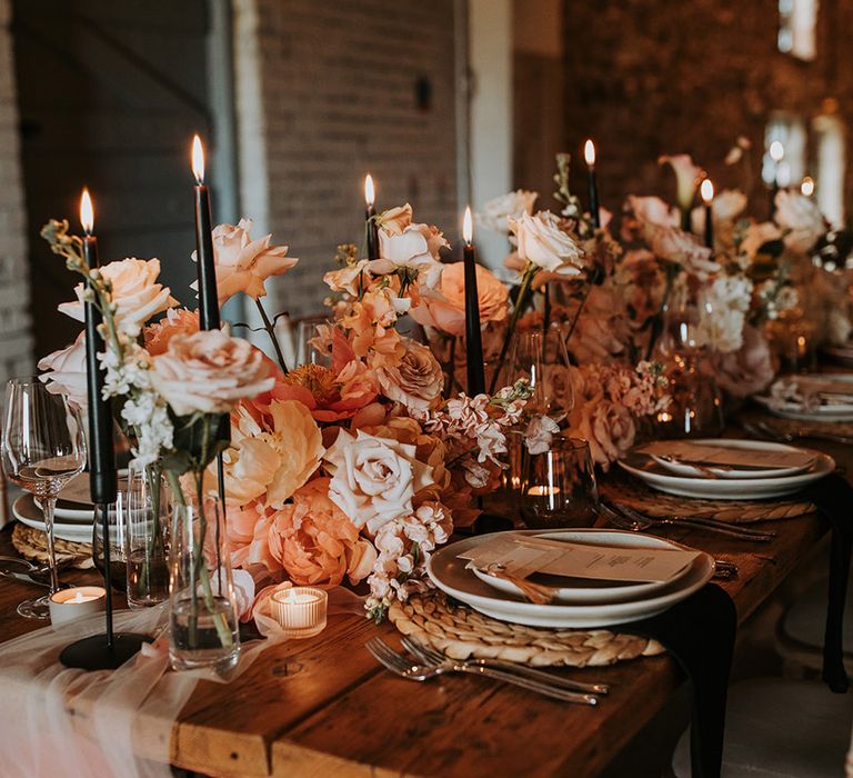 Romantic pink and black wedding tablescape with flower arrangements and more 