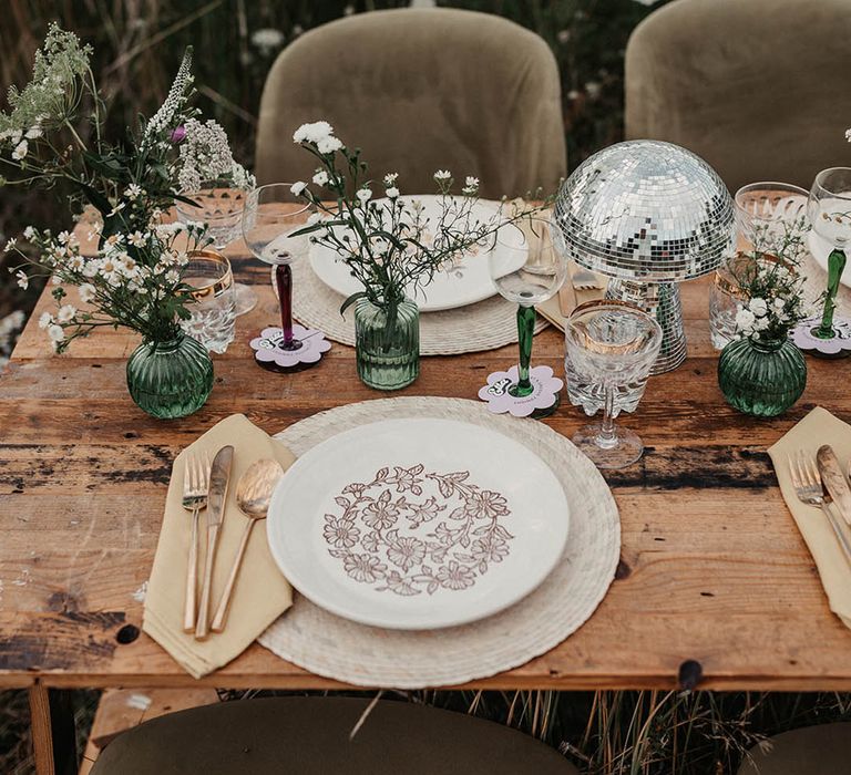 Green vases, green coloured glassware with mushroom disco balls, painted plates and gold cutlery 