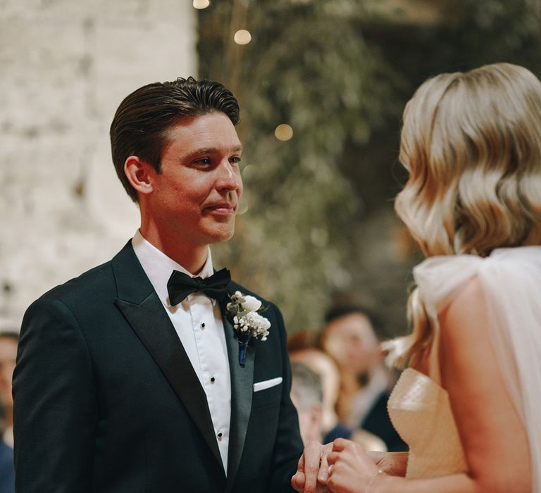 Rustic luxe wedding with groom in a black tuxedo and bride in sparkling Eva Lendel wedding dress 