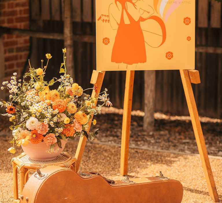 Colourful orange and yellow retro wedding signage with flower decor 