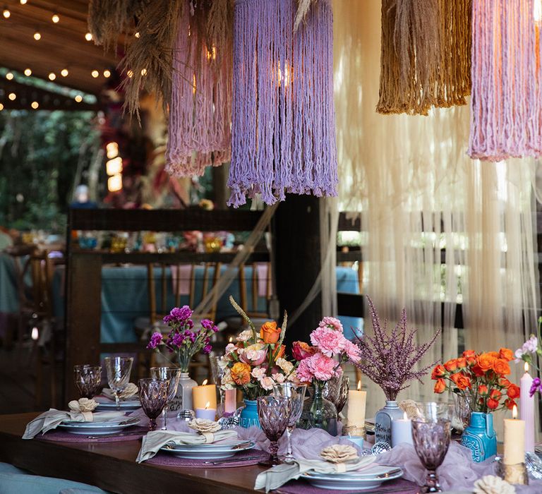 Purple and pink tassel statement lighting with pampas grass installation at destination Brazil wedding 