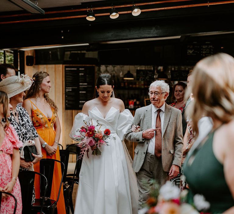 Father of the bride in beige suit walking down the aisle with the bride in a strapless wedding dress at The Shack Revolution 