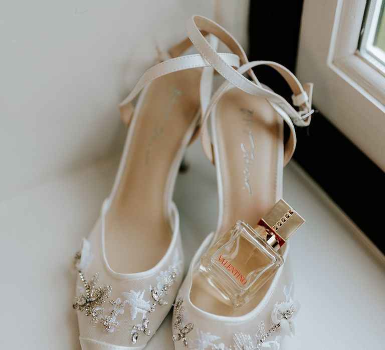 White delicate heeled wedding shoes with bridal perfume from Valentino 