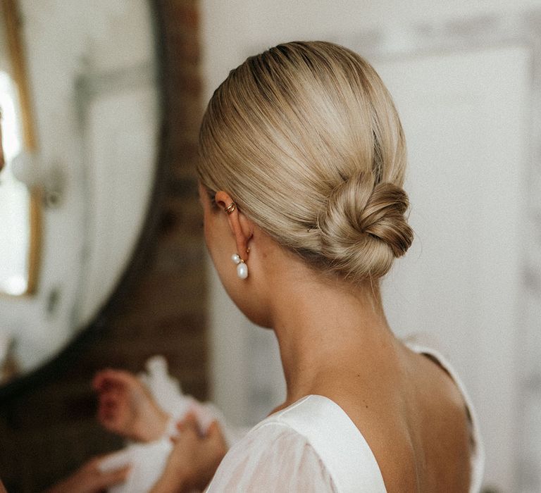 Bride wearing her blonde hair in a sleek bun updo wedding hairstyle for the stylish and chic city wedding 