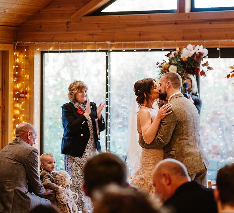 The bride and groom share their first kiss as a married couple at Styal Lodge wedding venue