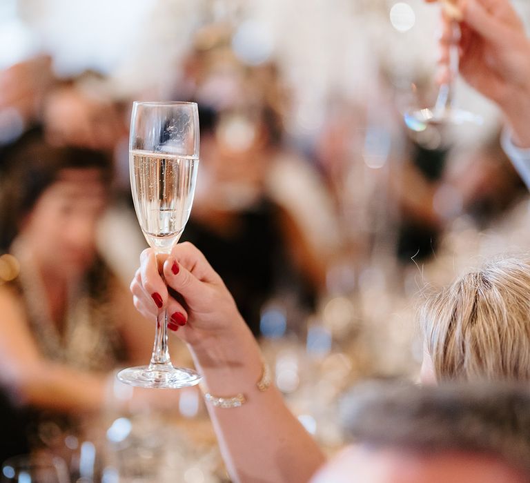 Wedding guests raise their glasses in a toast 