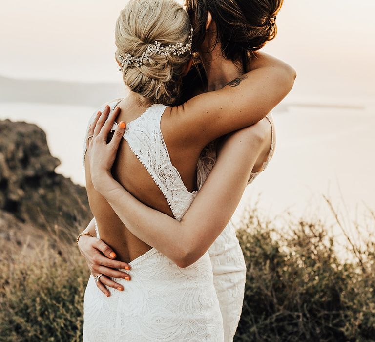 The brides share an embrace as they look out to the views from the Greek island of Santorini 