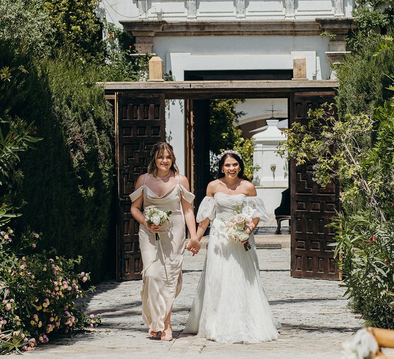 Finca Monasterio Southern Spain wedding with the bride and bridesmaid walking down the aisle together 