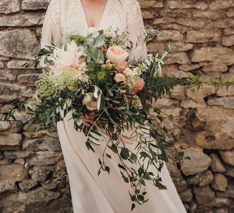 Bride in Hope & Ivy dress holding an oversized bouquet 