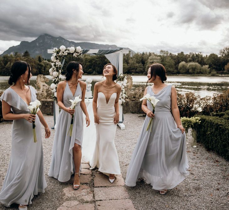 Bridal party portrait with bridesmaids in grey Jenny Too dresses and bride in strapless Reem Acra dress