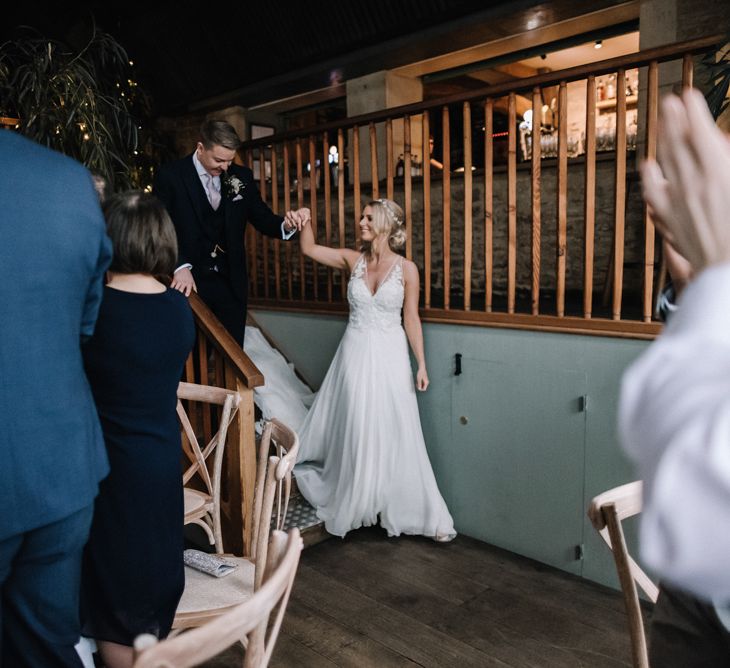 Bride and groom making an entrance at rustic barn wedding