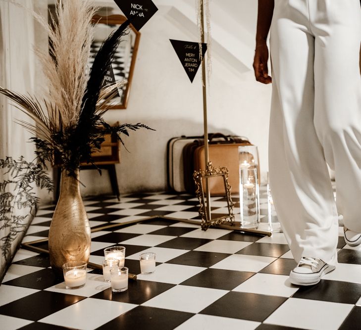 Bride walks through hall with black & white tiles 